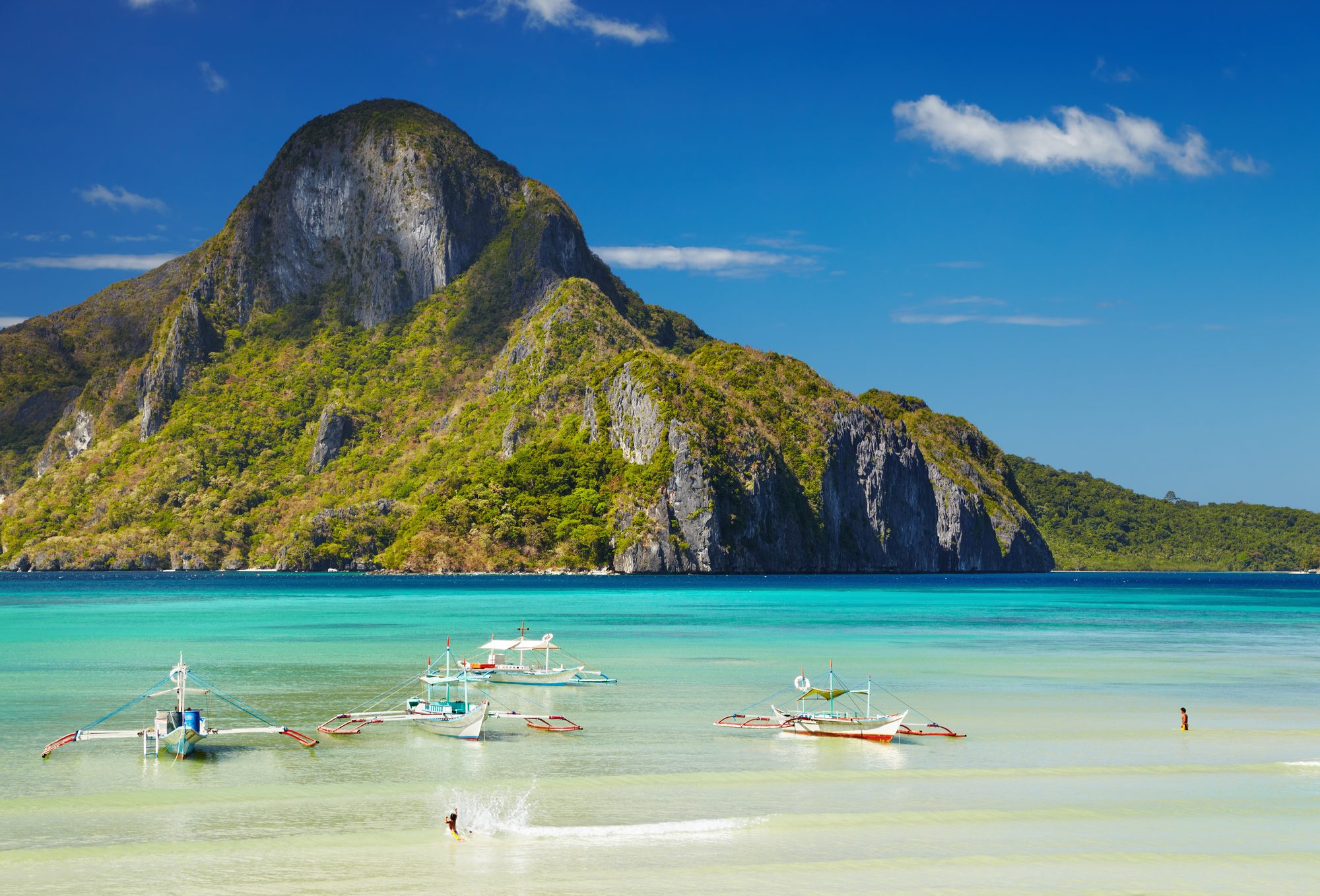 Tropical island bay with turquoise water and boats